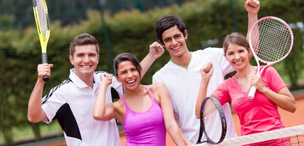 Excited group of tennis players with arms up