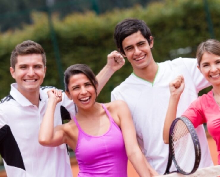 Excited group of tennis players with arms up